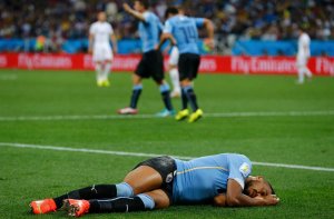 Alvaro Pereira lay motionless immediately after colliding with the knee of another player. Damir Sagolj/Reuters via NYTimes (see article for url)
