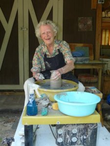Caryl looks pleased with herself while throwing pots.